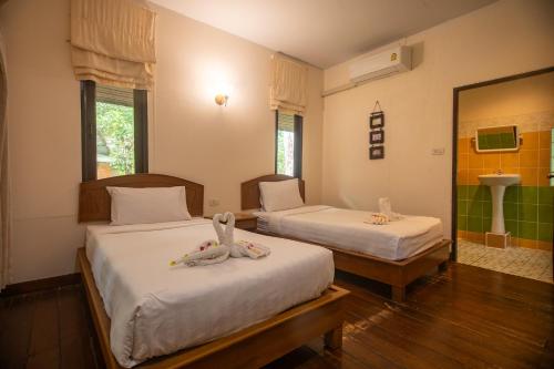a bedroom with two beds with towels on them at The Vatika Resort and Spa in Ao Nang Beach