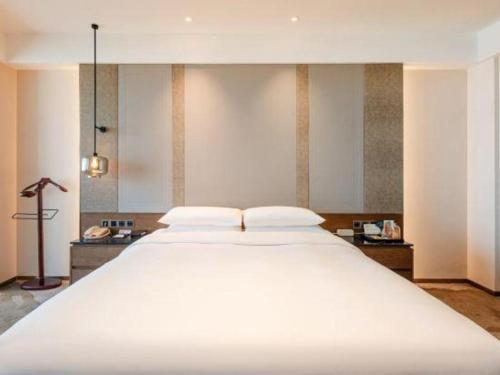 a large white bed with two pillows on it at Grand Metropark Hotel Chongqing in Chongqing