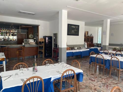 a dining room with tables and chairs and a bar at Hotel Helvetia in Grado