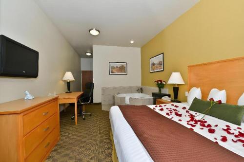 a hotel room with a bed and a desk and a television at Best Western Plus Guymon Hotel and Suites in Guymon