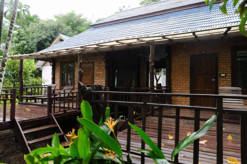 a house with a wooden deck with a black fence at The Vatika Resort and Spa in Ao Nang Beach