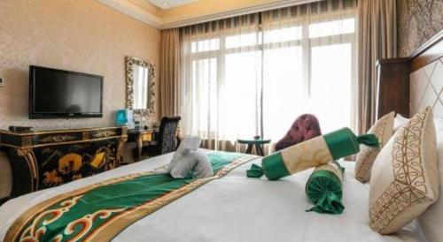 a bedroom with a large bed with stuffed animals on it at Hohhot Inner Mongolia Hotel in Hohhot