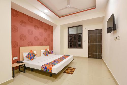a bedroom with a large bed and a television at FabHotel Blue Stone in New Delhi