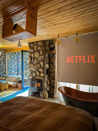 a bedroom with a wall with a stone fireplace at Cabana DenZ in Măguri