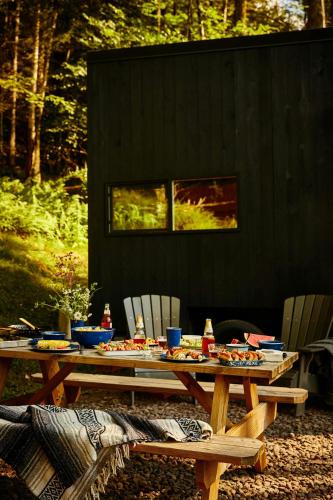 a picnic table and chairs with food on it at Postcard Cabins Hill Country in Wimberley