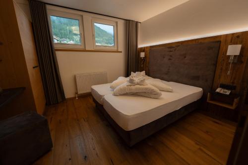 a bedroom with a bed with towels on it at Alpenhotel Regina in Nauders