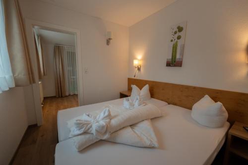 a bedroom with a white bed with towels on it at Alpenhotel Regina in Nauders