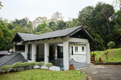 a small white house with a black roof at LilyJoe Treehouse Serendah in Serendah