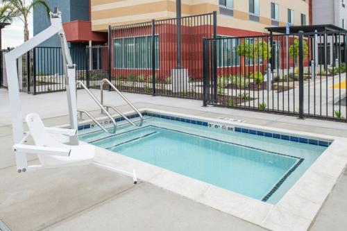 a swimming pool with a chair next to a building at Fairfield by Marriott Inn & Suites Stockton Lathrop in Lathrop