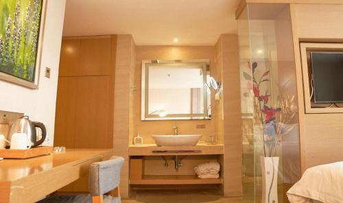a bathroom with a sink and a mirror at Zmax Hotel·Yantai Shimao Binhai Plaza in Yantai