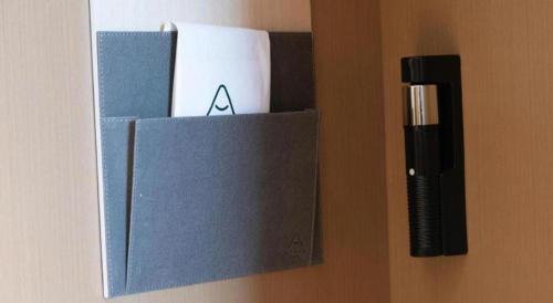a box on a wall with a pen and other items at Atour Hotel Weihai Shidao in Dongshan