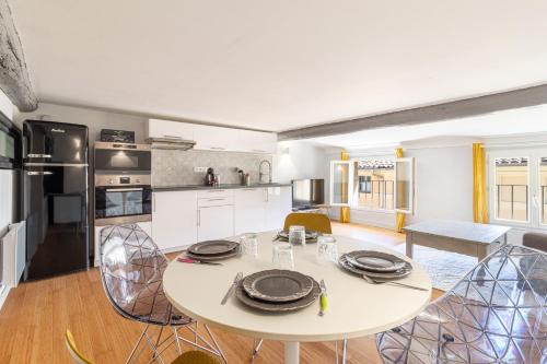 a kitchen and dining room with a white table and chairs at Appartement charme & confort in Aix-en-Provence