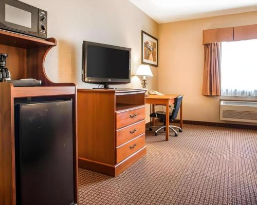 a hotel room with a flat screen tv and a desk at Quality Inn in Sidney