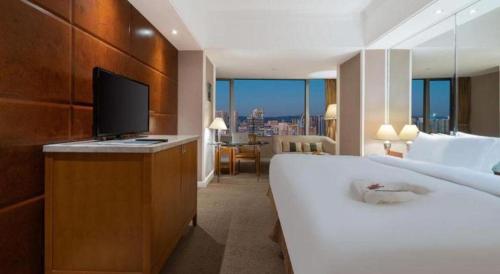 a hotel room with a bed and a television in it at Kai Wah Plaza International Hotel in Kunming