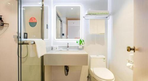 a bathroom with a sink and a toilet and a mirror at GreenTree Inn Shanghai Jingan Railway Station Xinzha Road Business Hotel in Shanghai