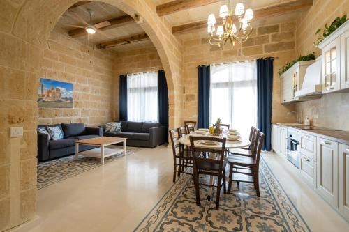 a kitchen and living room with a table and chairs at Peonja Suite in Xagħra