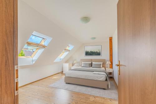 a white bedroom with a bed and a window at Byt 3kk in Frýdek-Místek