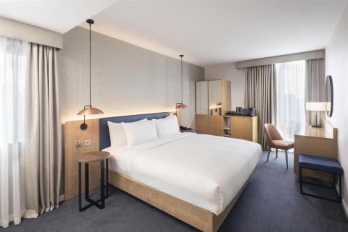 a hotel room with a large bed and a desk at Hilton Garden Inn Bristol City Centre in Bristol