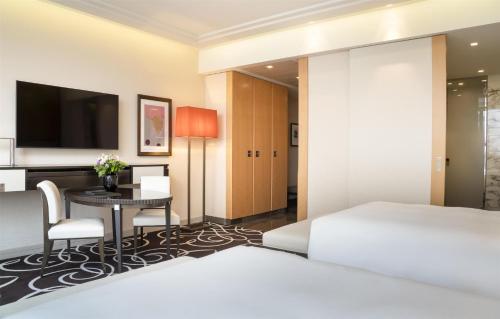 a hotel room with a bed and a desk and a television at Waldorf Astoria Berlin in Berlin