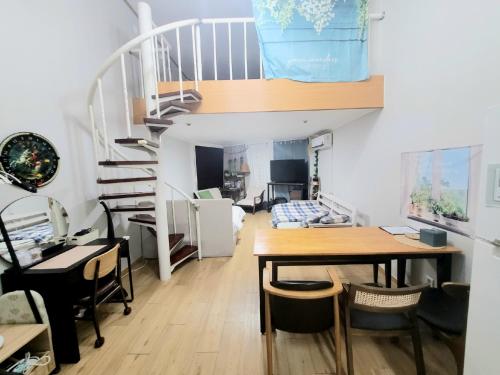 a living room with a table and a staircase at Like U Residence in Goyang