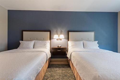 two beds in a hotel room with blue walls at Hampton Inn Mesa Verde/Cortez Co in Cortez