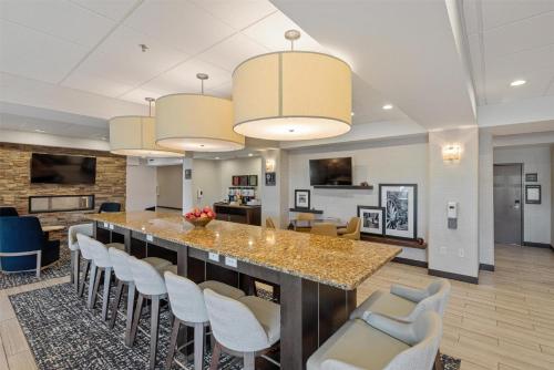 a large kitchen with a large island with white chairs at Hampton Inn Mesa Verde/Cortez Co in Cortez