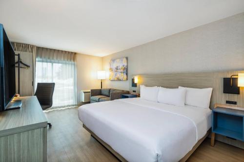 a large white bed in a hotel room at Comfort Inn in Laval