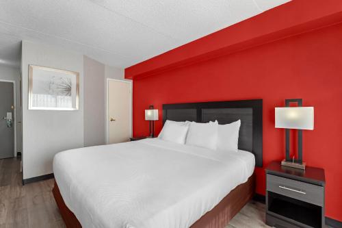 a large bed in a room with a red wall at Quality Inn & Suites 5585 Ambler Drive Mississauga Ontario in Mississauga