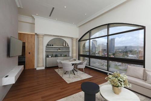 a living room with a table and a large window at Clarion Hotel Real Tegucigalpa in Tegucigalpa
