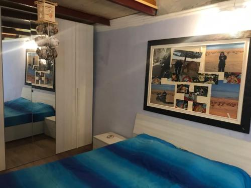 a bedroom with a blue bed and a picture on the wall at Il Borgo del Ghiro in Irola