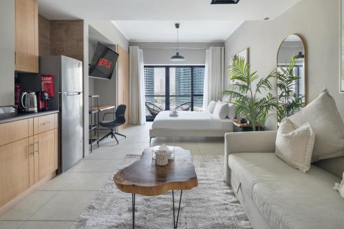 a living room with a couch and a table at Chic JLT Studio, Lake View, Pool, Metro Access in Dubai