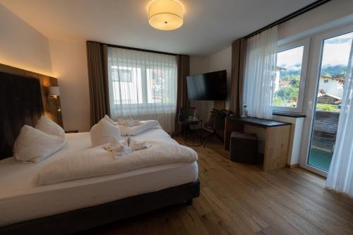 a hotel room with a bed and a large window at Alpenhotel Regina in Nauders