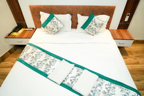 a bedroom with a bed with white sheets and pillows at Naina Staycation Udaipur in Udaipur