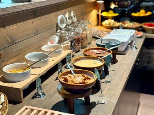 a buffet with bowls of food on a table at Riddergaarden Mountain Lodge, Beitostølen in Beitostøl