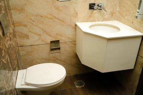 a bathroom with a white toilet and a sink at Naina Staycation Udaipur in Udaipur