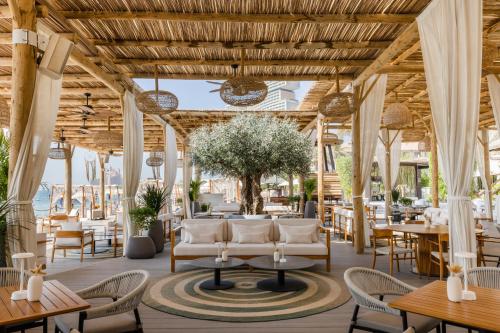 a restaurant with white chairs and tables and tablesktopktop at Sofitel Dubai The Palm Resort & Spa in Dubai
