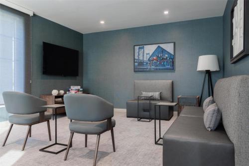 a living room with a couch and chairs and a tv at Home2 Suites By Hilton Kittery in Kittery