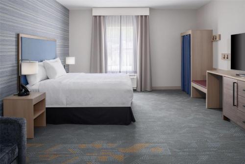 a hotel room with a bed and a television at Home2 Suites By Hilton Kittery in Kittery