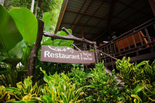 a sign in the middle of some plants at The Vatika Resort and Spa in Ao Nang Beach