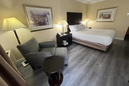 a hotel room with a bed and a chair at Quality Inn Saint-Jean-sur-Richelieu in Saint-Jean-sur-Richelieu