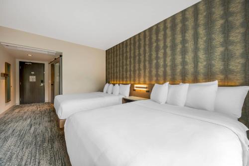 a hotel room with two beds and a wall at Cambria Hotel Portland - Pearl District in Portland