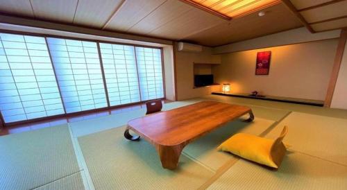 a living room with a wooden table and a couch at Hotel Miyama in Chichibu