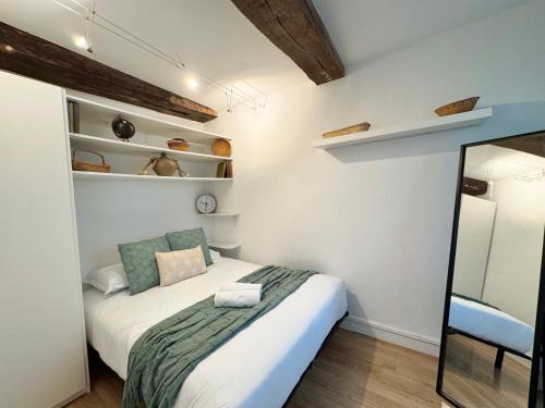 a small bedroom with a bed and a mirror at Le Saint Georges avec terrasse, Hyper centre ville in Rennes