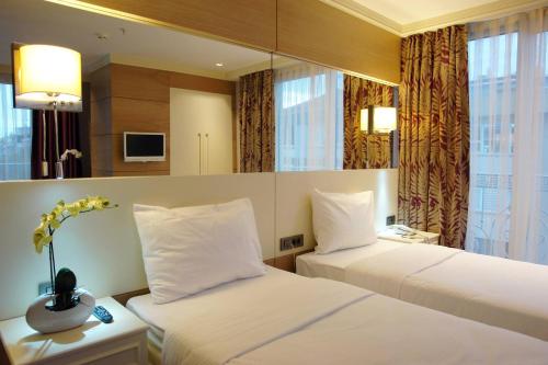 a hotel room with two beds and a window at Le Mirage Hotel in Istanbul