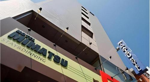 a building with a sign on the side of it at Mimatsu Hotel in Mito