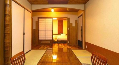 a room with a table and chairs and a bedroom at Yukemuri no sato azumaya in Beppu