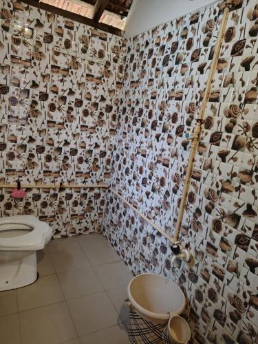 a bathroom with a toilet and a wall covered in pictures at Coconut tree cafe Gokarna in Gokarna
