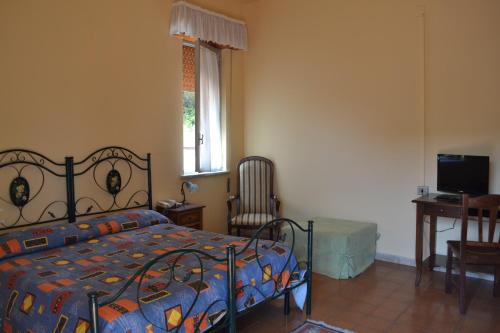 a bedroom with a bed and a desk and a window at Hotel Miravalle in Misilmeri