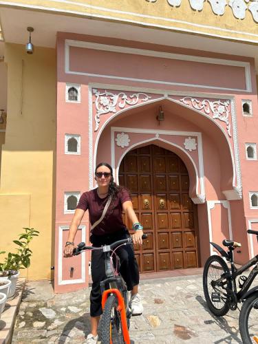 a man riding a bike in front of a building at House of Amer in Jaipur