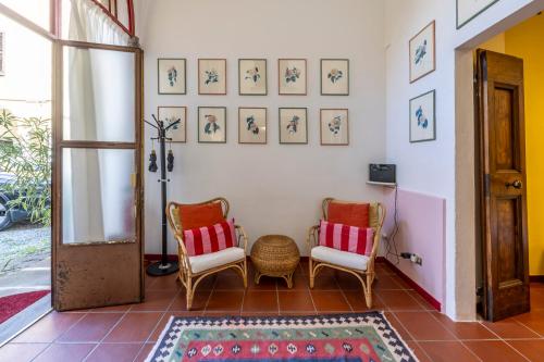 a room with two chairs and pictures on the wall at Cozy Corner in Brescia Center - Dogeshouse in Brescia